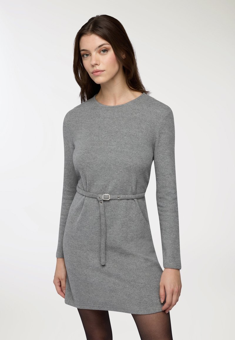 Szara dzianinowa sukienka z długimi rękawami, okrągłym dekoltem i paskiem w talii. Miękka faktura i dopasowany krój podkreślają sylwetkę.