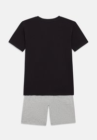 Zwart katoenen T-shirt met korte mouwen, gecombineerd met grijze katoenen shorts met een zijzak, weergegeven op een witte achtergrond.