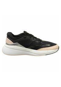 Zapatilla deportiva negra y beige con suela blanca gruesa, parte superior de malla y ante, y cordones negros, mostrada en vista lateral sobre fondo blanco.