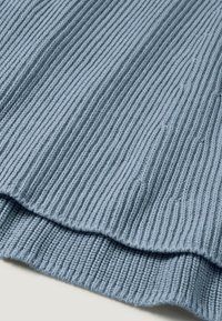 Hellblauer, gerippter Strickstoff mit einer strukturierten Oberfläche, der feine vertikale Linien aufweist und ein weiches, gemütliches Aussehen hat. Die Kanten sind leicht gewellt.