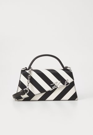 Czarno-biała torebka w ukośne paski z górnym uchwytem, odpinanym paskiem na ramię oraz srebrnym podpisem "Karl" na przedniej klapie.