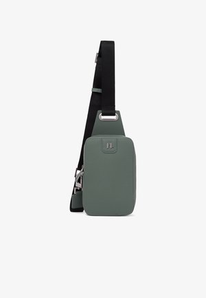 Mazs taisnstūrveida zaļš ādas plecu somiņa ar melnu regulējamu siksnu un sudrabotu rāvējslēdzēja rotājumu.