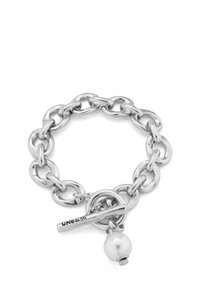 Pulsera de plata gruesa hecha de cadenas de metal unidas, con un cierre de palanca y un acento de perla colgante. Presenta una textura pulida y un brillo brillante.