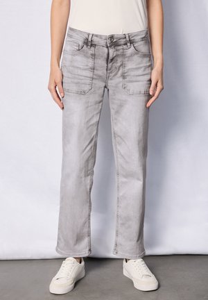 Pantalon en denim gris clair avec un design à jambe droite, doté de poches avant et d'une texture lisse. Associé à des baskets blanches.