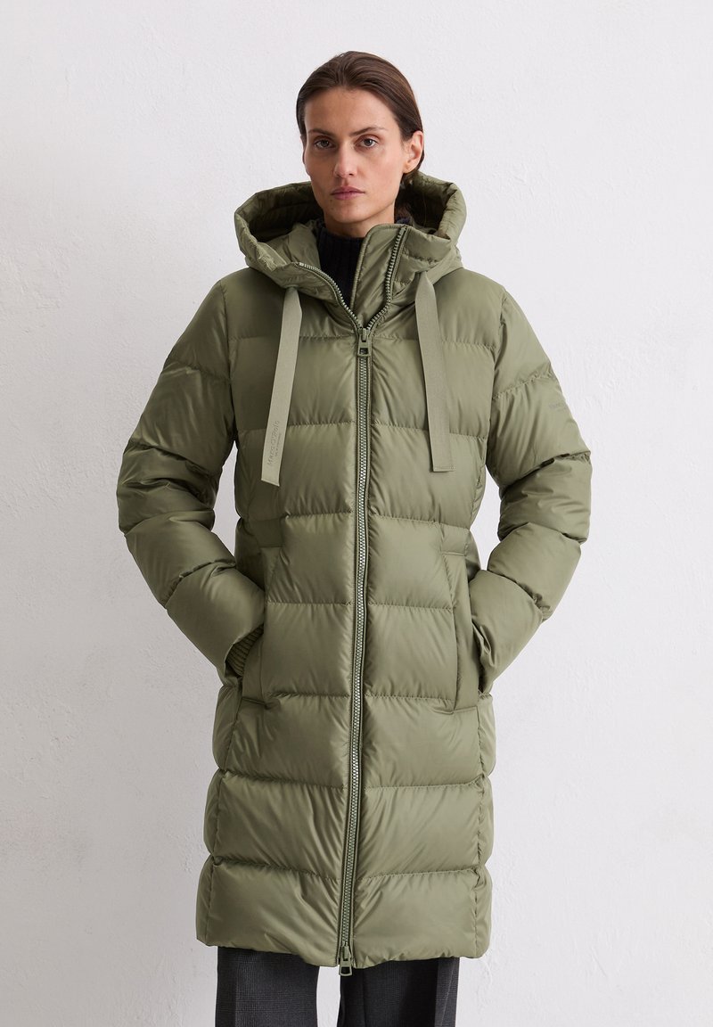 Gewatteerde jas met capuchon in olijfgroen. Voorzien van een ritssluiting aan de voorkant, twee zijzakken en een effen patroon. Gemaakt van een glad, waterafstotend materiaal.
