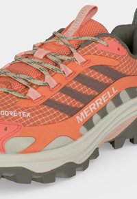 Παντόφλα πεζοπορίας Merrell σε πορτοκαλί και γκρι με ανώτερο μέρος από δίχτυ Gore-Tex, σχέδιο στα κορδόνια και ανθεκτική σόλα για εξωτερική χρήση.