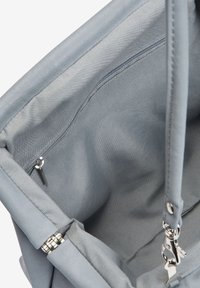 Interno della borsa tote grigia con rivestimento in tessuto morbido, tasca con zip e dettagli in metallo argentato. Design strutturato con una texture liscia.