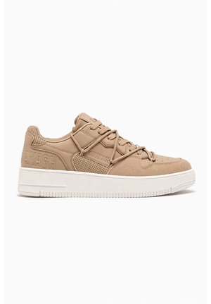 Beige lav top sneaker med perforerede og ruskindspaneler, præget branding på siden, beige snørebånd og tyk hvid gummisål.