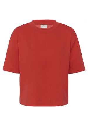 Crvena majica kratkih rukava s okruglim izrezom i opuštenim krojem te malom oznakom marke unutar ovratnika.