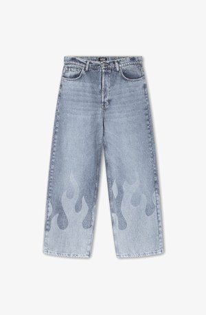 Világoskék farmernadrág széles lábbetéttel; a lábszárak alsó részén egy diszkrét lángmintával, világosabb árnyalatban. Klasszikus öt zsebes kialakítás.