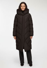 Długi czarny płaszcz puchowy z wysokim kołnierzem i wzorem w zygzak, z długimi rękawami i prostym krojem.