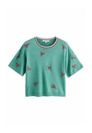 Grøn kortærmet strikbluse med rødt blomsterbroderi spredt ud over og en rund halsudskæring med rød og hvid kant.