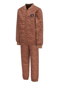 Quiltad brun jumpsuit med dragkedja, ribbad mudd och diamantmönster. Har en logotyp patch på bröstet och en mjuk textur över hela.