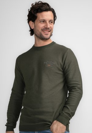Olive green crewneck sweatshirt made of textured fabric, featuring ribbed cuffs and hem, with a small logo on the chest.