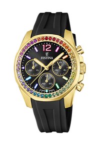 Orologio con cinturino in silicone nero e cassa dorata, quadrante nero, cristalli colorati sulla lunetta e tre sotto-quadranti per le funzioni di cronografo.