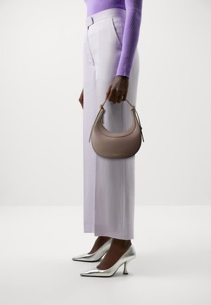 Sac à main de style hobo en cuir grainé taupe clair avec des accessoires en métal doré ; porté à la main. Assorti à un pantalon lavande et des escarpins argentés pointus.