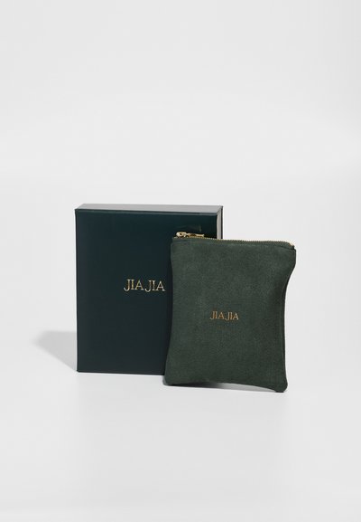 Zeleni nubuk kovčeg s zlatnim logotipom, uz odgovarajuću tamnozelenu kutiju. Kovčeg ima zatvaranje na patentni zatvarač.