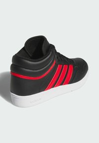 Czarne wysokie trampki z trzema czerwonymi paskami, białą gumową podeszwą, gładką skórzaną teksturą i sznurowaniem. Zaprojektowane do codziennego noszenia.