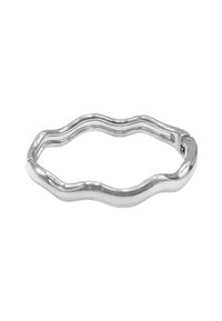 Anello in metallo argento con un design ondulato. Texture liscia, forma aperta con bordi che si undulano, offrendo un'estetica contemporanea.