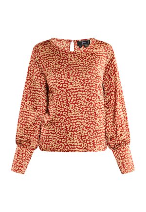 Piros blúz krém színű leopárdmintával, kerek nyakkivágással és kulcslyuk részlettel a háton. Hosszú ujjak, amelyeknél redőzött mandzsetta van, laza fazonnal.