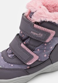 Stivaletti viola alla caviglia con colletto in pelliccia sintetica rosa, motivo a pois e doppie cinghie in velcro. Realizzati in materiali sintetici con una finitura testurizzata.