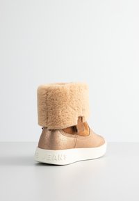 Pink metallic ankelstøvle med en blød beige manchet og hvid gummisål. Har en struktureret overflade og et diskret logo på hælen.