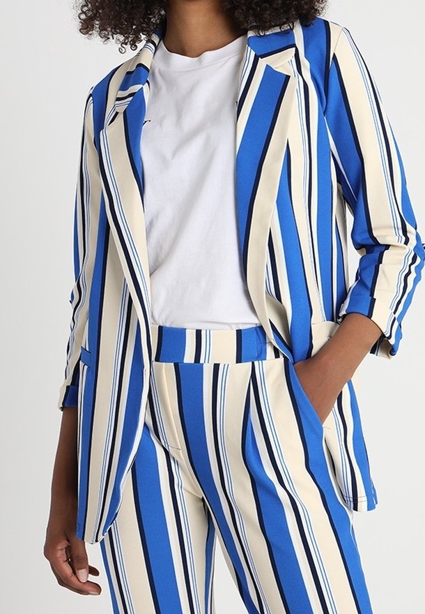 Ensemble blazer et pantalon à rayures bleues et crème, avec des rayures verticales, un col et des poches. Le tissu semble lisse avec une finition nette.