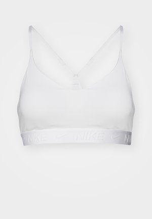 Sujetador deportivo blanco con tirantes ajustables, diseño de escote en V y banda elástica con el texto "Nike" en relieve. Textura de tela suave, estilo minimalista.