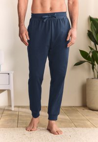Navy blue lightweight pajama pants with an elastic waistband, drawstring tie, and ribbed cuffs. Made from soft fabric, offering a relaxed fit.