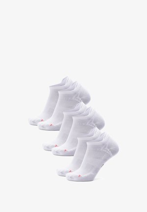 Bílé kotníkové ponožky vyrobené z prodyšné tkaniny, s vroubkovanými manžetami a jemnými červenými akcenty poblíž prstů, uspořádané v řadě.