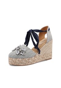 Espadrillas con zeppa caratterizzate da una tomaia in tessuto grigio intrecciato, impreziosita da gioielli trasparenti e nastri di tessuto blu marino per legature alla caviglia su una piattaforma in juta.