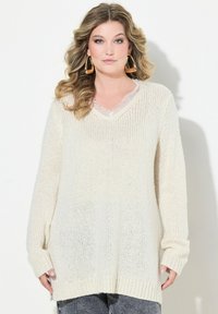 Pull à col V à manches longues en tricot blanc cassé. Présente une coupe ample, un ourlet côtelé et des détails en dentelle au niveau de l'encolure.