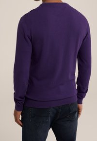 Lila långärmad tröja med rundad halsringning och ribbad nederkant. Slät textur, figurnära design och minimala sömdetaljer. Bar tillsammans med mörka jeans.