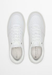 Weiße Sneakers aus glattem Leder, mit flachen Schnürsenkeln, perforiertem Zehenbereich und weichem Innenfutter. Sie verfügen über eine dezente Markenkennzeichnung und eine strapazierfähige Gummisohle.