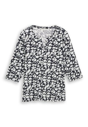 Schwarze Bluse mit weißem Blumenmuster, Dreiviertelärmeln und einem runden Ausschnitt mit kleinem V-förmigem Einschnitt.