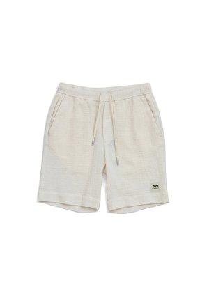 Pantalones cortos beige con cordón, bolsillos laterales y un pequeño parche con logo en la parte inferior de la pierna izquierda, hechos de tejido texturizado y ligero.