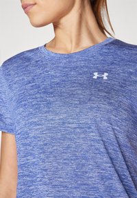Blåmelerad tränings T-shirt med rund hals, korta ärmar och en vit Under Armour-logotyp på den övre vänstra bröstområdet.