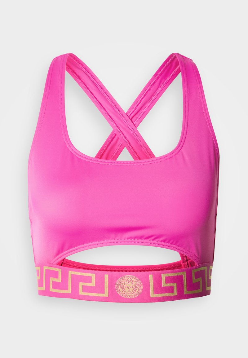 Roze sportbeha met een kruisband op de rug en een uitsparing onder de borst. Voorzien van een metallic gouden Grieks sleutelpatroon op de elastische band.