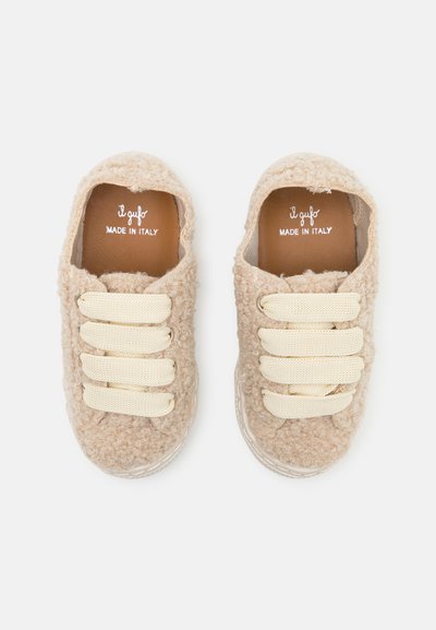 Baskets en textile beige et moelleux avec trois lacets élastiques blanc cassé, forme arrondie et intérieur en cuir, étiquetées "il gufo, FABRIQUÉ EN ITALIE."