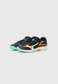 Black athletic shoes with orange accents and a white midsole. Features a textured upper and a mint green outsole. Laces are black.