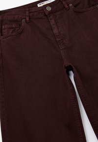 Bordeaux katoenen jeans met een rechte pijp, zichtbare zakstiksels, metalen knoopsluiting en een label op de tailleband.