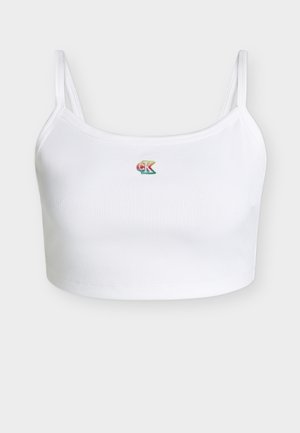 Hvit ribbestrikket croptop med tynne stropper og liten regnbuefarget "CK"-logo midt foran.