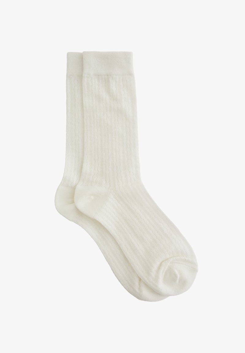 Calzini di cotone bianchi con una texture a coste e bordi rifiniti. Il design presenta sottili strisce verticali, che migliorano la presa e il comfort.