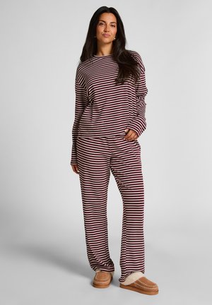 Ensemble de vêtements de détente rayé dans des tons bordeaux et crème, comprenant un haut à manches longues ample et un pantalon assorti. Tissu doux avec une coupe décontractée.