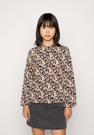 Blusa de manga longa floral em preto com padrões em rosa, branco e castanho. Apresenta um decote alto e pregas no peito. Textura de tecido suave.