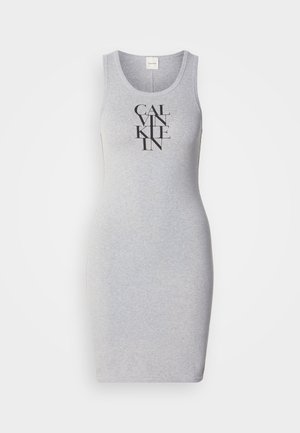 Szürke ujjatlan ruha, amely testhez simuló fazonnal rendelkezik, és a "CALVIN KLEIN" szavak vastag fekete betűkkel függőlegesen vannak nyomtatva az elülső részén.