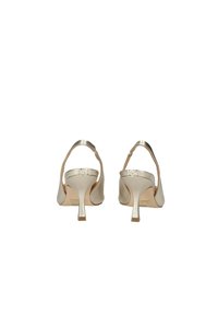 Scarpe con tacco alto in satin beige con un design elegante, schienale aperto e cinturino alla caviglia regolabile. Presentano un sottile tacco a stiletto.