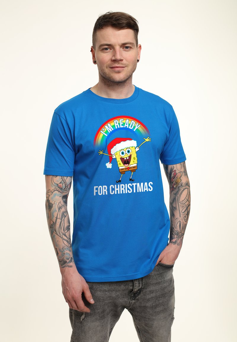 Camiseta de algodón azul con un diseño navideño que muestra a un personaje con un gorro de Santa, con el texto "ESTOY LISTO PARA NAVIDAD."