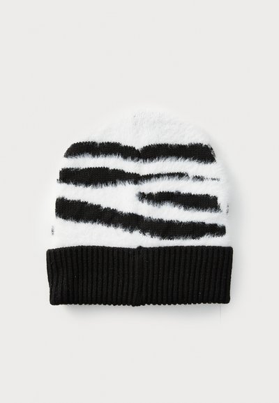 Svart och vit randig stickad mössa med en fluffig textur och en ribbad svart manschett. Design med växlande tjocka och tunna ränder.