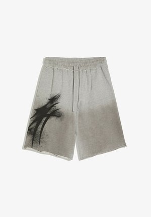 Jasnoszare szorty do kolan z elastycznym pasem i sznurkiem, z czarnym abstrakcyjnym wzorem z farby w sprayu na lewej nodze.